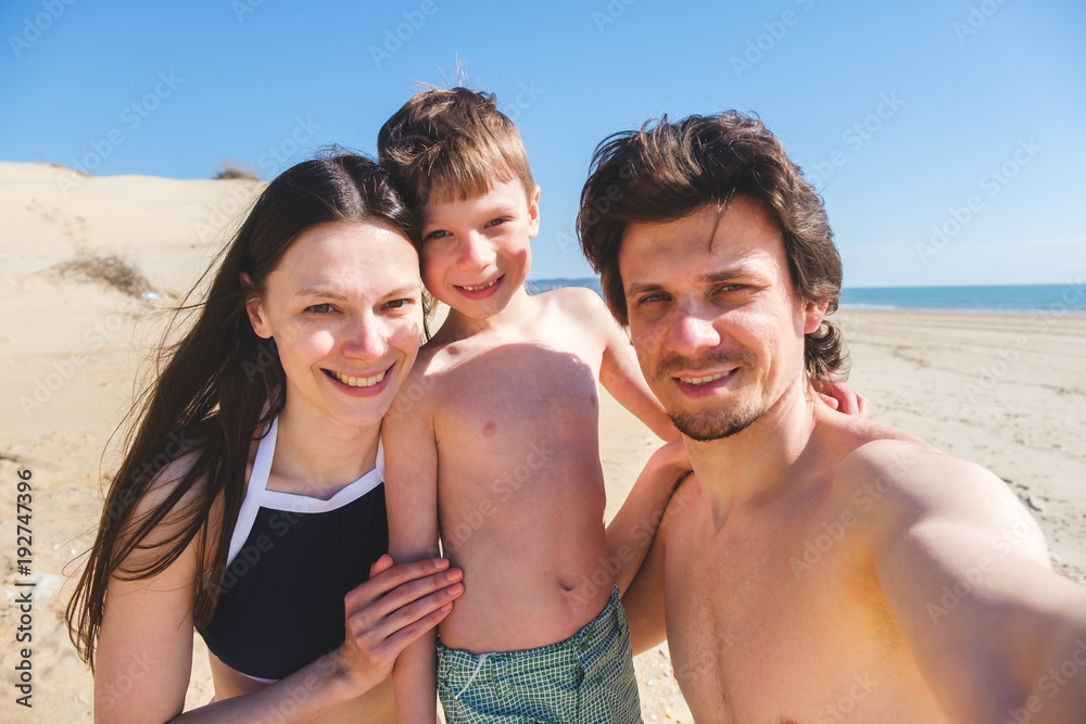 Happy family mom, son and dad onthe sand beach with dunes. Happy family mom, son and dad onthe sand beach with dunes.