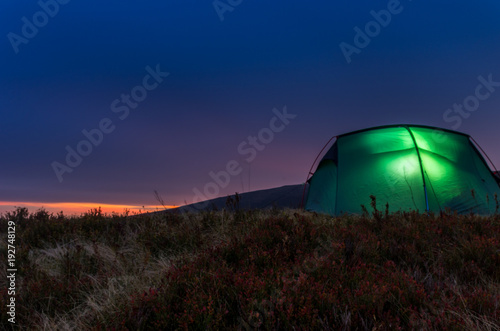 Tourist tent in the evening mountains. Sunset in the mountains. photo