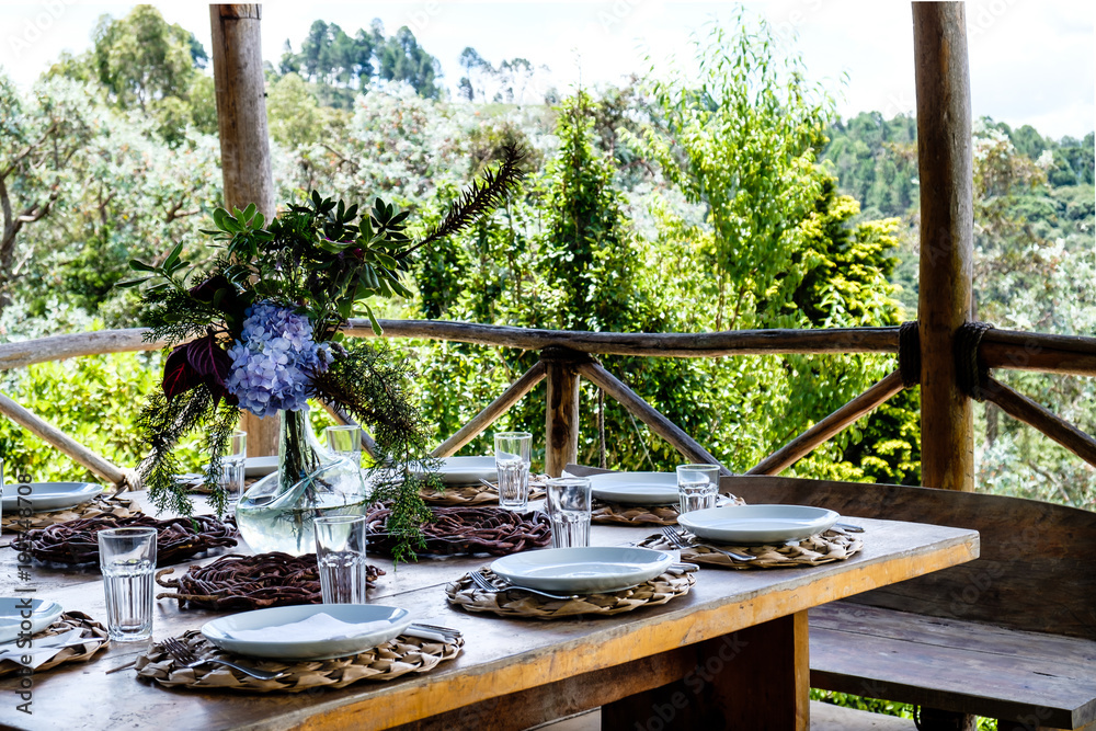 Fototapeta premium Table set in an outside hut with beatiful views to the forest