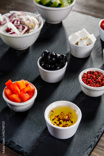 Ingredients to Greek salad on wooden background