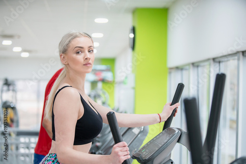 Fitness couple running doing cardio on treamill in fitness center gym
