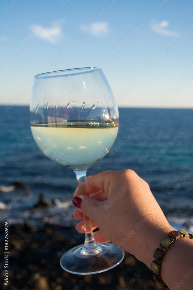 Tasting of glass of cold white wine on outdoor terrace with sea view