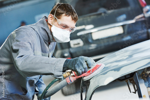 auto repairman grinding autobody bonnet photo