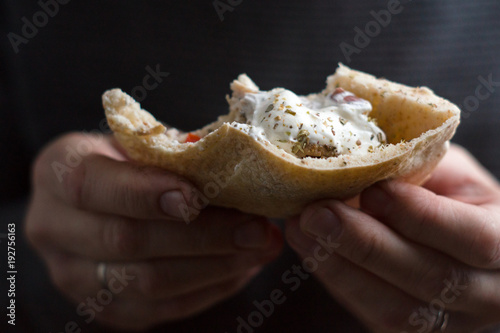 Man is holding a bite of a fajita close-up