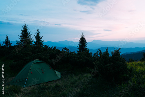 Picturesque summer landscape with colorful sunrise on Carpathian mountains. Lush green forest from pine tree on backgound. Travel concept