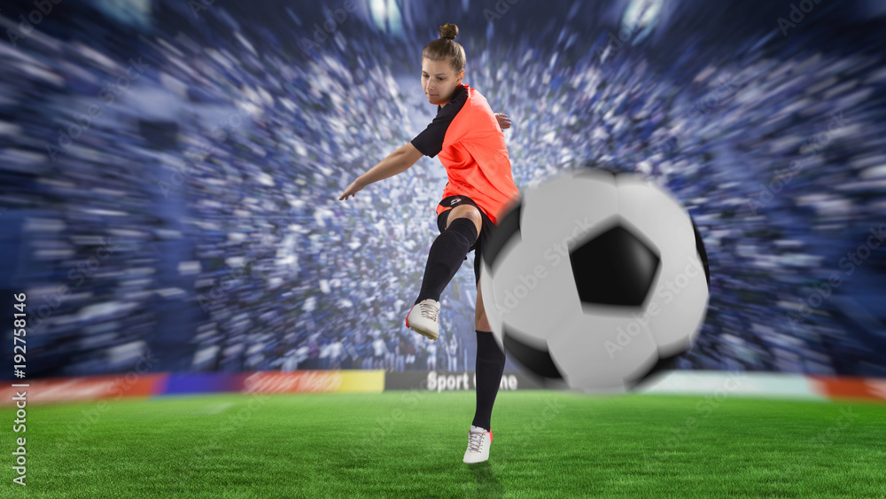 female football player in orange uniform kicking the ball