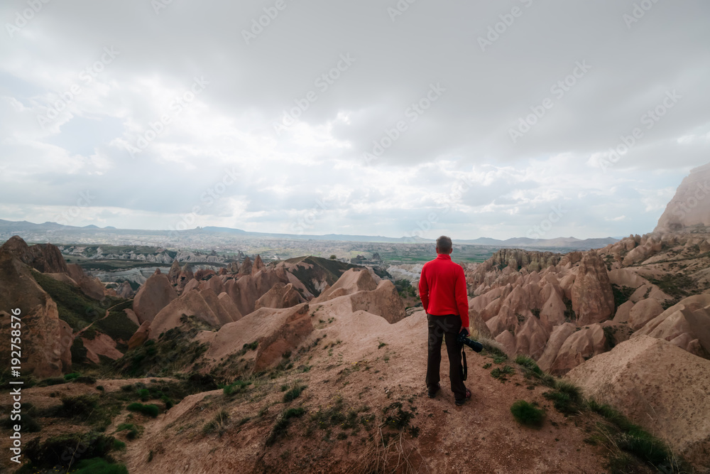 Amazing day in Cappadocia mountains, Turkey. Photographer stay on red rose valley in expectant of sunset. Landscape photography