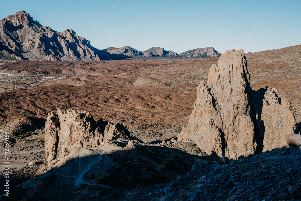 Tableland with mountains on the background and rocks on the front with the big shadow in the morning. Teide National Park. Tenerife
