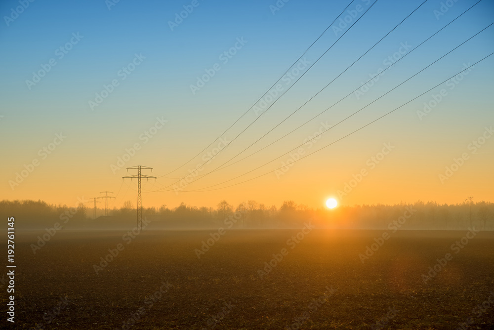 Landschaft mit Überland Stromleitungsnetz in der Morgensonne