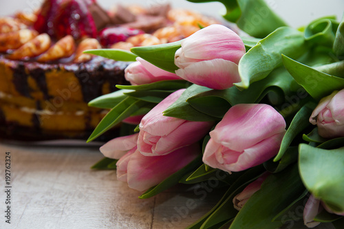 Fototapeta Naklejka Na Ścianę i Meble -  bouquet of tulips on rustic wooden board, and Easter cake