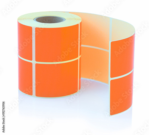 Orange label roll isolated on white background with shadow reflection. Color reel of labels for printers. Labels for direct thermal or thermal transfer printing. photo