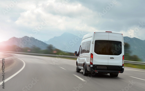 passenger bus van accelerating on a background of mountains
