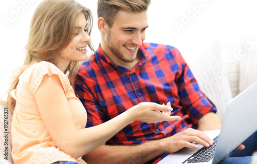young woman showing her boyfriend's photo on the laptop.