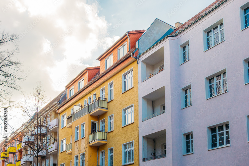 colorful houses in a row with big clouds