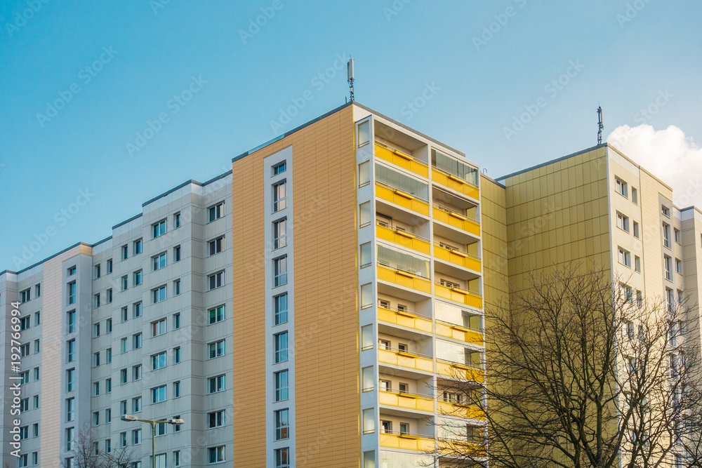Fototapeta premium orange and white plattenbau building in warm sunlight at berlin, lichtenberg