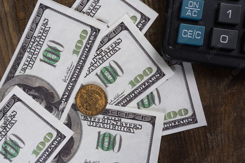Fototapeta premium Banknotes, coins calculator on the wood table