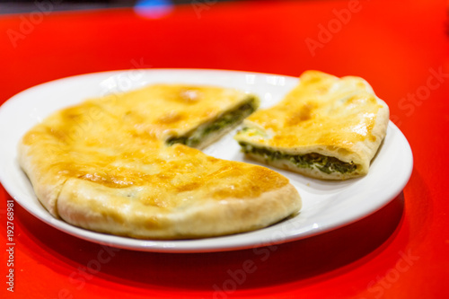 Traditional Ossetian pie lies on a plate.