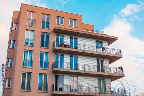 red and white colored building with big balcony on a cloudy day