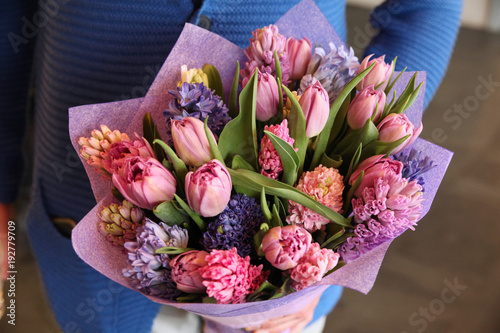 Purple bouquet of tulips and irises in the hands