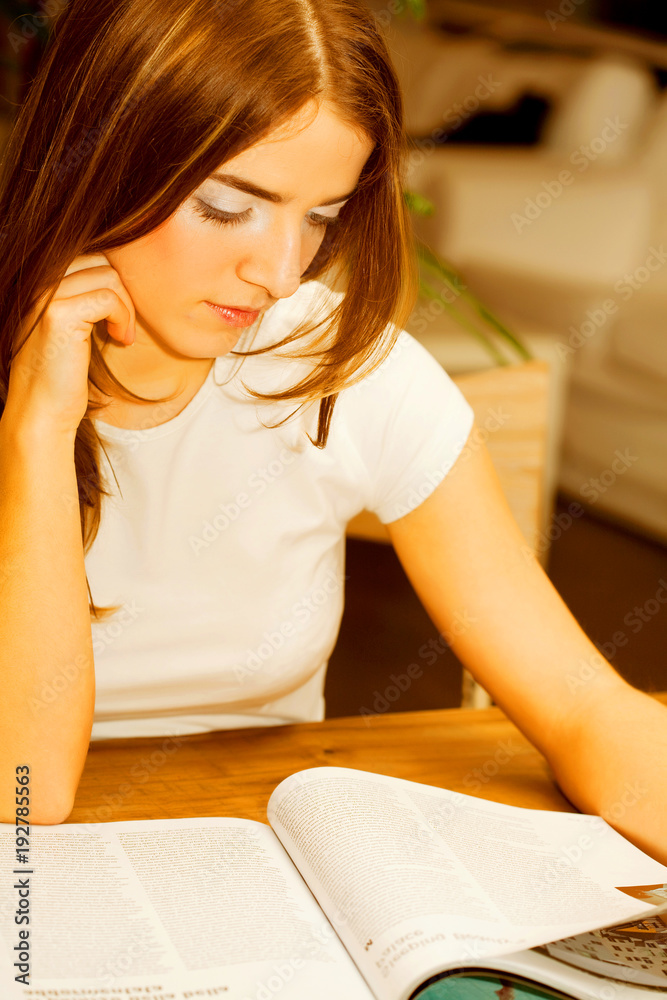 Obraz premium female reading a magazine at tea time
