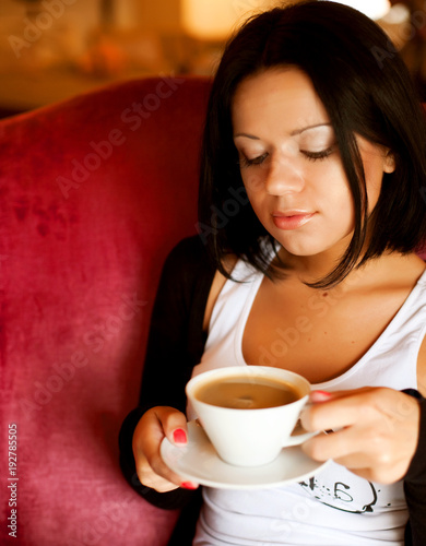 young woman sitting in a cafe drinking coffee