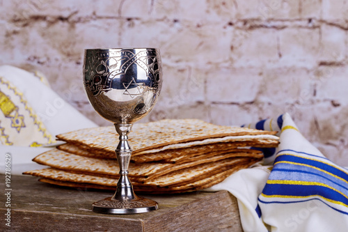 Jewish holidays Passover Pesach matzah and a silver cup full of wine with a traditional blessing photo