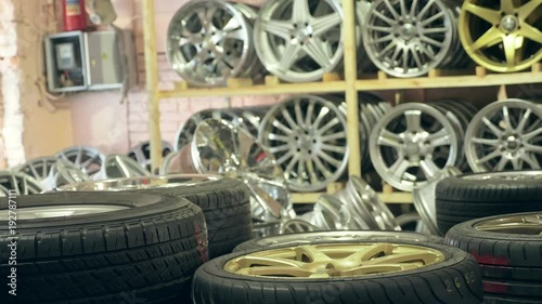 Alloy wheels in the store on the shelves. The camera moves from left to right. The discs are different and new. photo