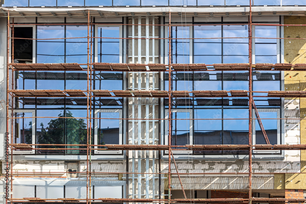 modern office building under construction. scaffolding at building site.