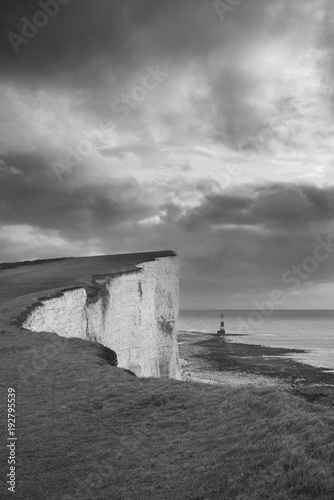 Stunning black and white landscape image of Beachy Headt lighthouse on South Downs National Park during stormy sky © veneratio