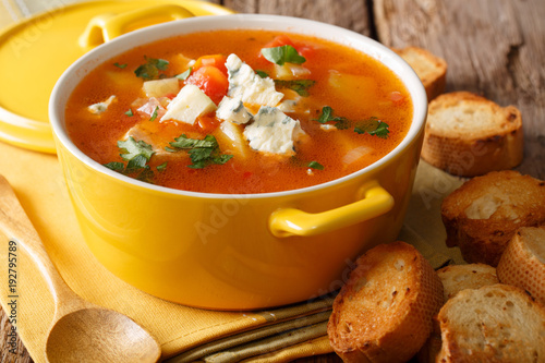 buffalo soup with chicken, vegetables and blue cheese closeup in the pan and toasted bread on the table. horizontal