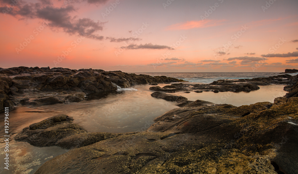 Long Exposure sunrise, colorful sky, volcanic rock beautiful seascape at Gran Canaria Island Coast in Spain.