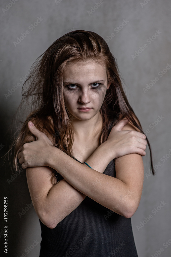 Scared and sad teen girl is clasping his shoulders