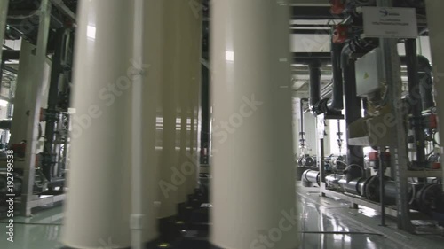 Employee Walks Past Stored Sealed Pipes in Factory photo