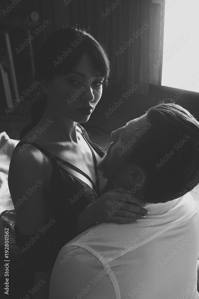 Strong Man and beautiful woman lying on the bed intimate atmosphere. Luxurious furniture and beautiful interior. A girl with black hair is a man without a shirt. Love and tenderness. Strong Man and beautiful woman lying on the bed intimate atmosphere. Luxurious furniture and beautiful interior. A girl with black hair is a man without a shirt. Love and tenderness.