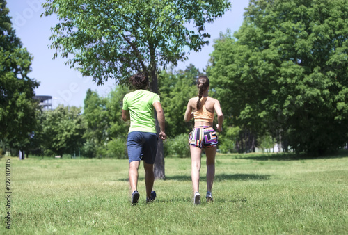 Young couple jogging at the green environment