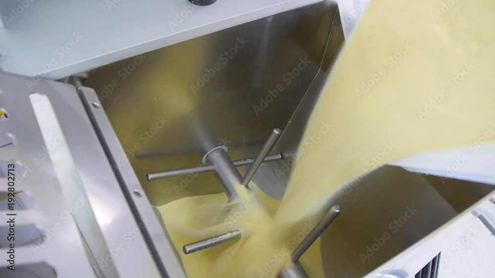 Wheat flour for making pasta poured into industrial dough mixer Wheat flour for making pasta poured into industrial dough mixer