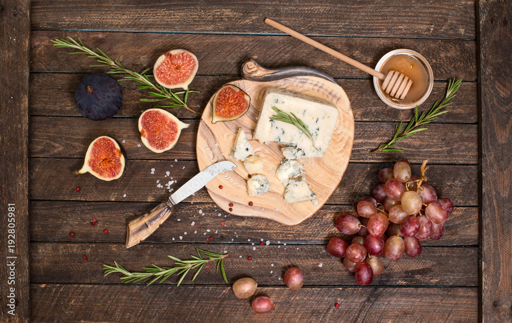 Roquefort  or Blue cheese serving with grapes, honey and figs. Cheese plate.
