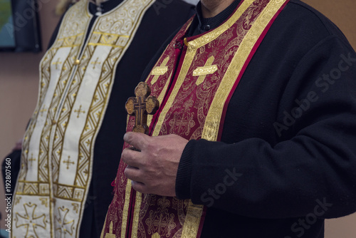 Orthodox priest holds a wooden cross in his hand