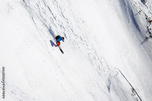 Fotografie Female freerider skiing down steep slope