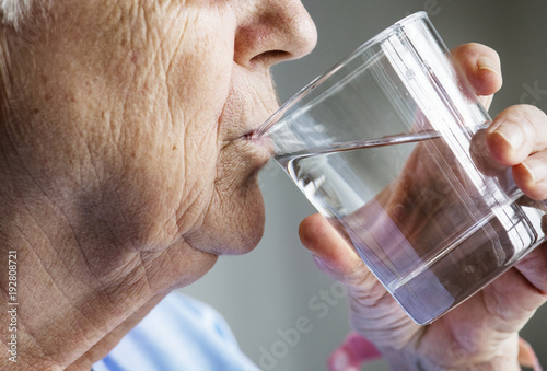 Side view of elderly woman drinking water photo