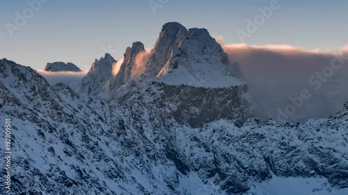 Snowy Tatra mountains peaks over clouds, Poland and Slovakia landscape, time lapse