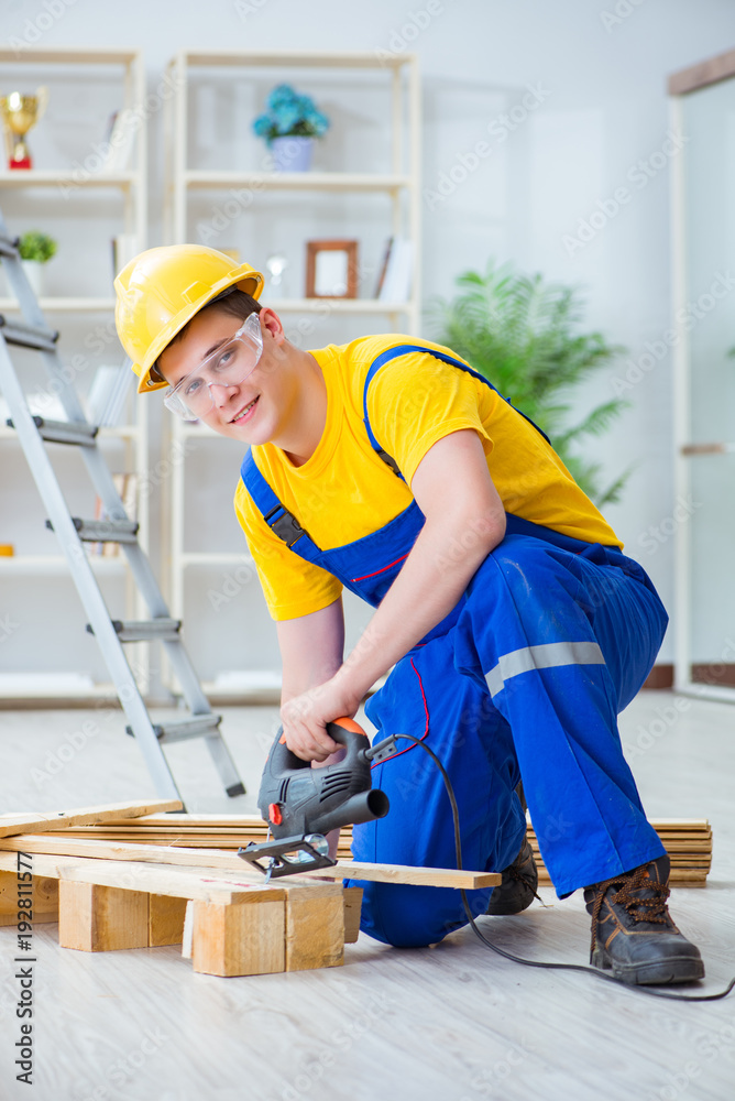 Young man assembling wood pallet