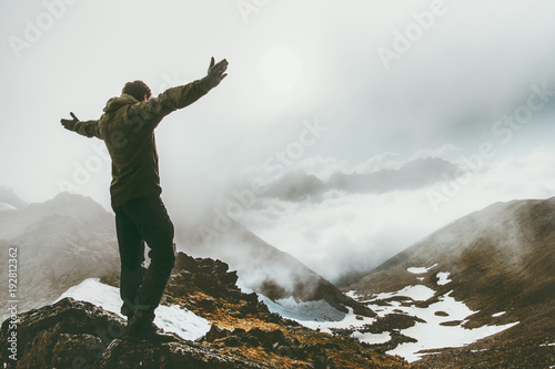 Raised hands Man on foggy mountain summit Travel success lifestyle survival concept adventure outdoor active vacations wild nature photo