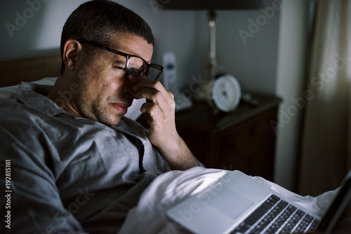 Принти на полотні Man using laptop on a bed