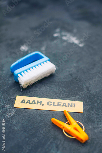 Cleaning house or office concept. Blue cleaning brush, AAAH, CLEAN inscription on a dark concrete background. Top view, closeup photo