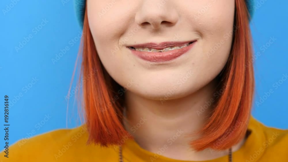 Unrecognisable woman smiling at the camera on blue background Unrecognisable woman smiling at the camera on blue background