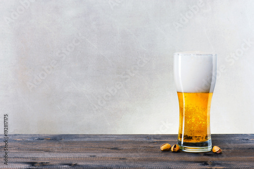 Glass of light beer on the wooden table