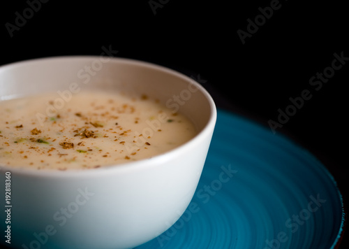 cream soup with herbs on black background