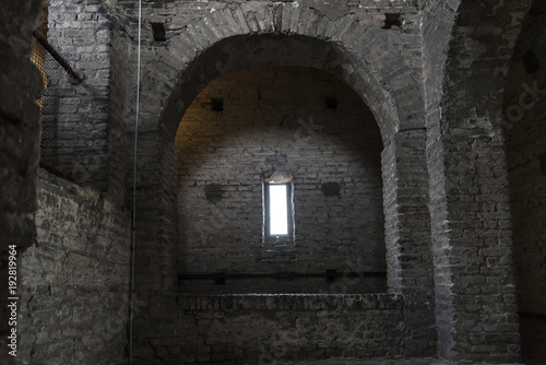 Stone interior with window of an old steeple crypt, located inside an ancient catholic church