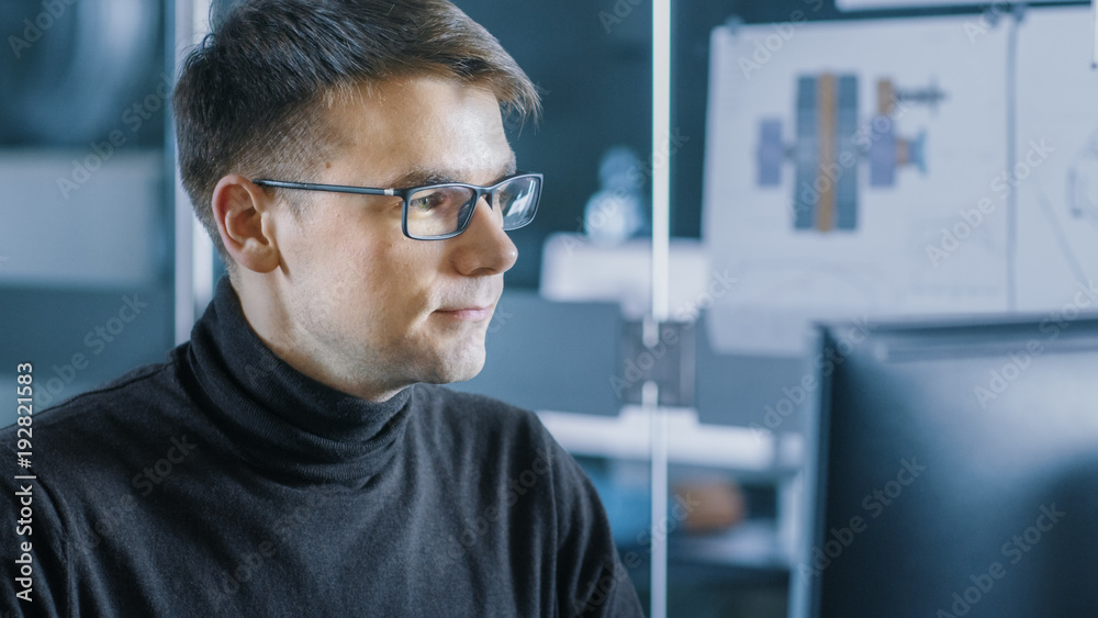 Young Male Industrial Engineer Works on a Personal Computer. Handsome Smart Man in the Bright Modern Office. Young Male Industrial Engineer Works on a Personal Computer. Handsome Smart Man in the Bright Modern Office.
